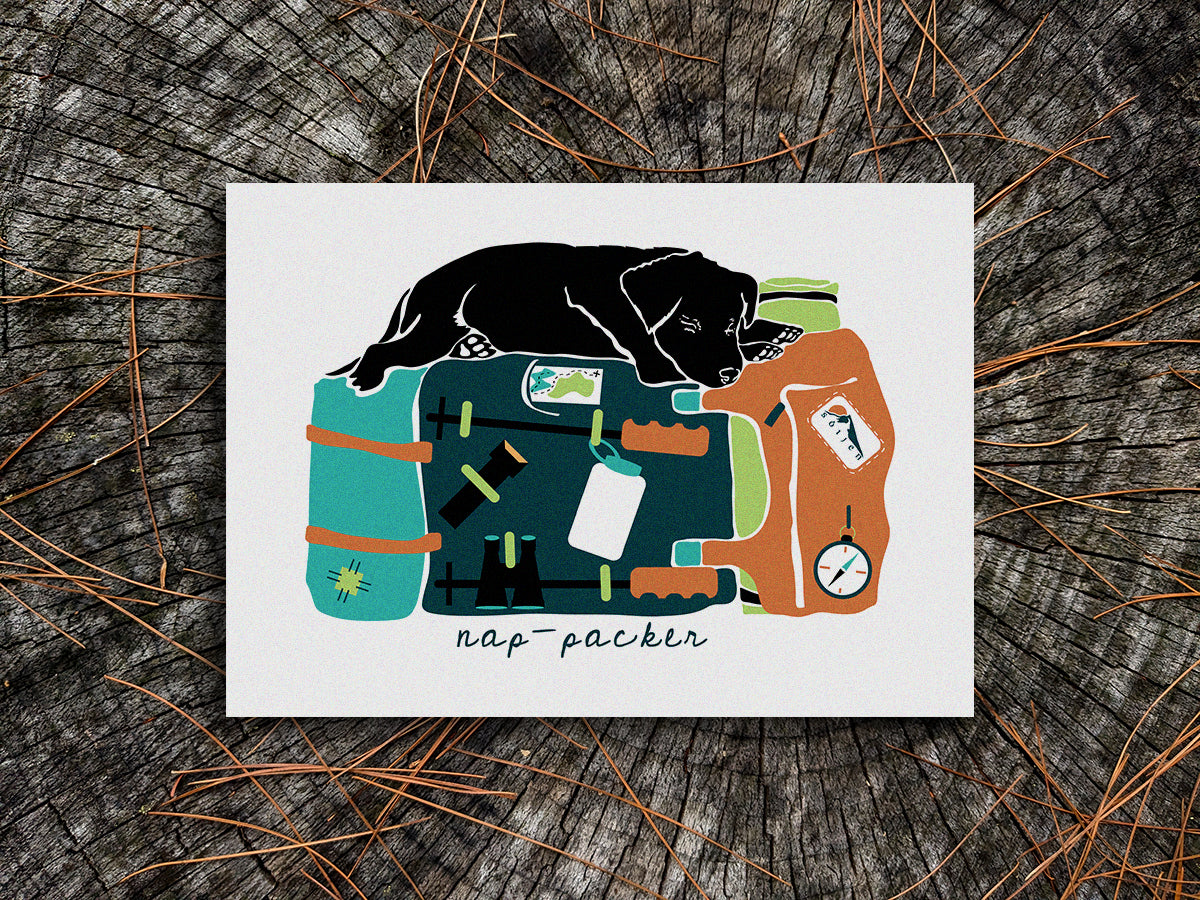 Art print of a black dog sleeping on top of a colorful backpack with the text nap-packer