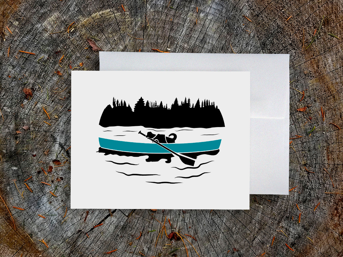 Greeting card with a black dog paddling a blue canoe with wood background