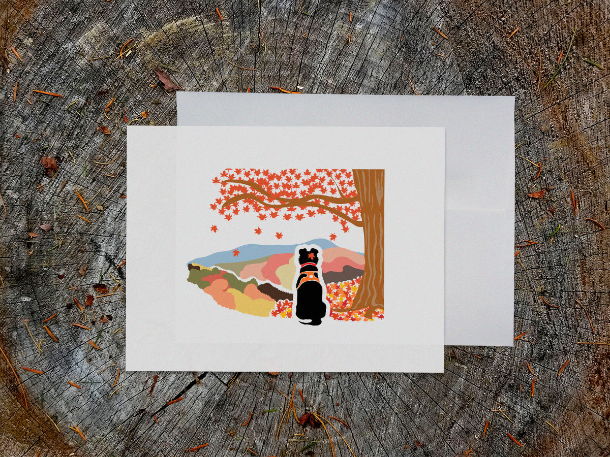 Greeting card with image of black dog underneath a maple tree with red fall foliage and mountains in the background.