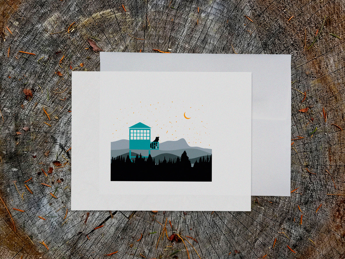Greeting card of black dog sitting in a fire tower overlooking the mountains and stars.