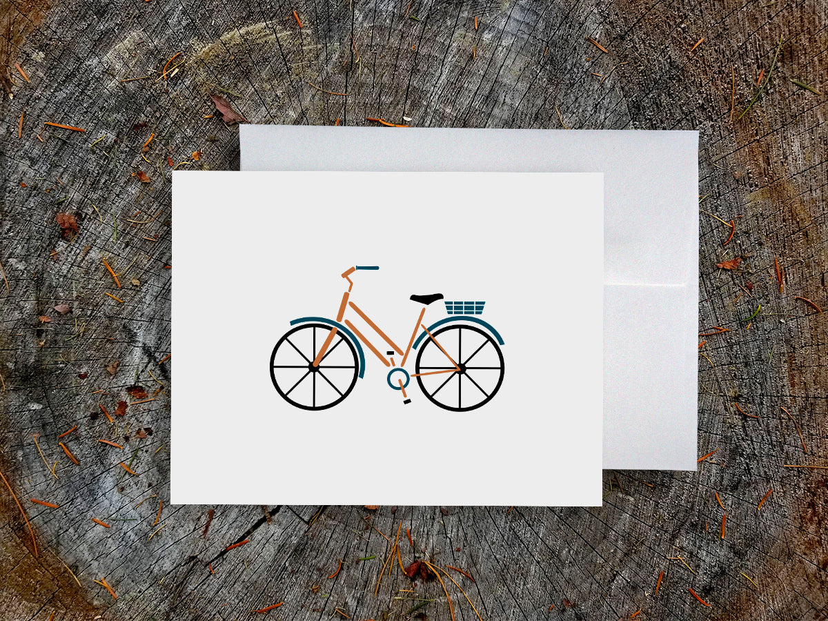 Greeting card with a yellow cruiser bike with basket with wood background