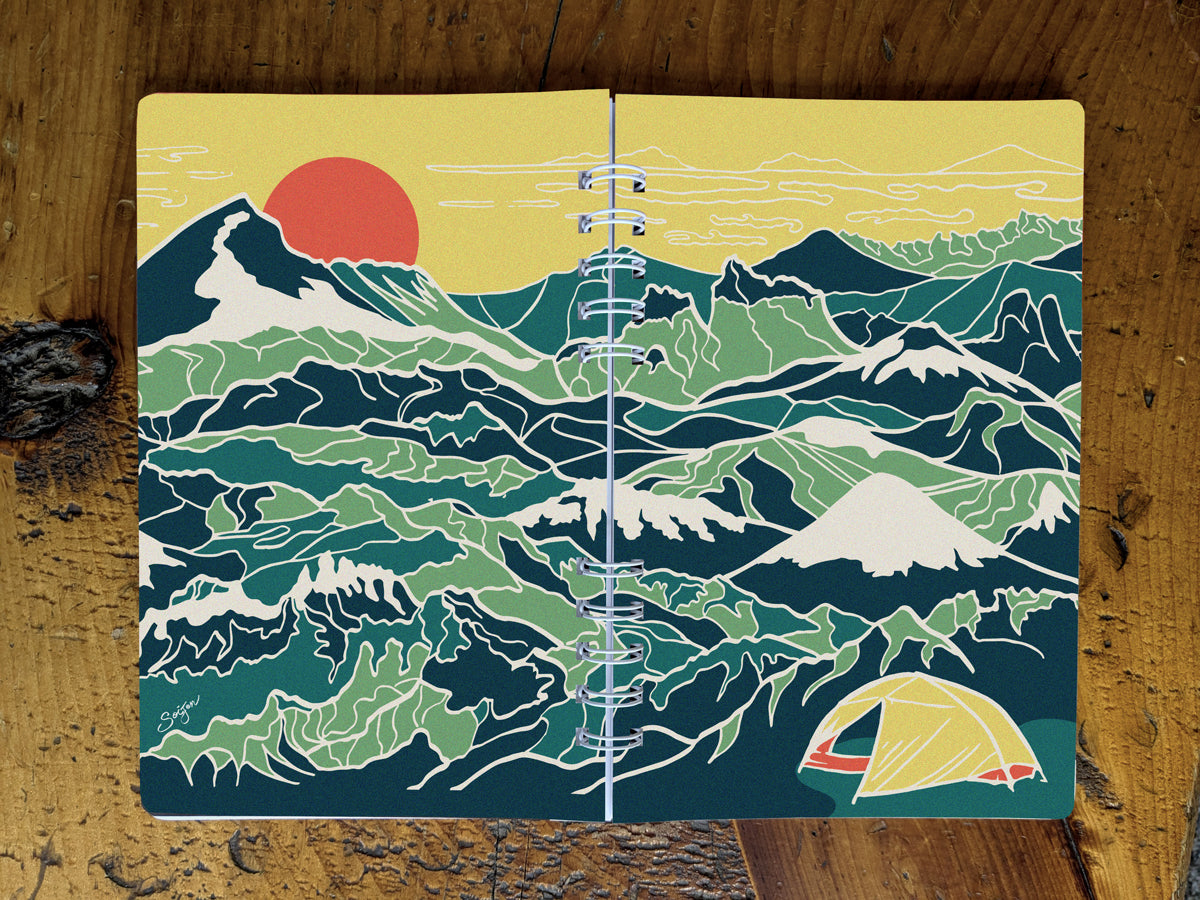 Notebook with illustration of a yellow tent among a background of blue and green mountains.