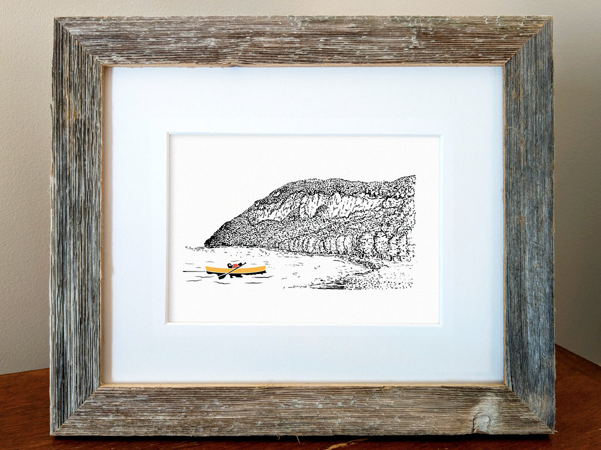 Framed art print of a dog paddling a yellow canoe with a mountain in the background