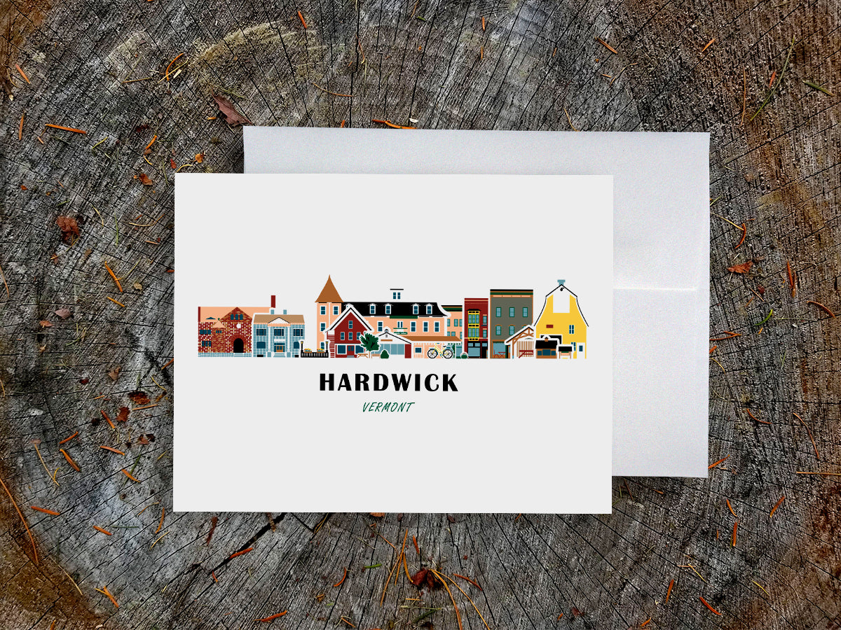 Greeting card with image of buildings arranged in a city skyline with the text Hardwick Vermont on a table with envelope.