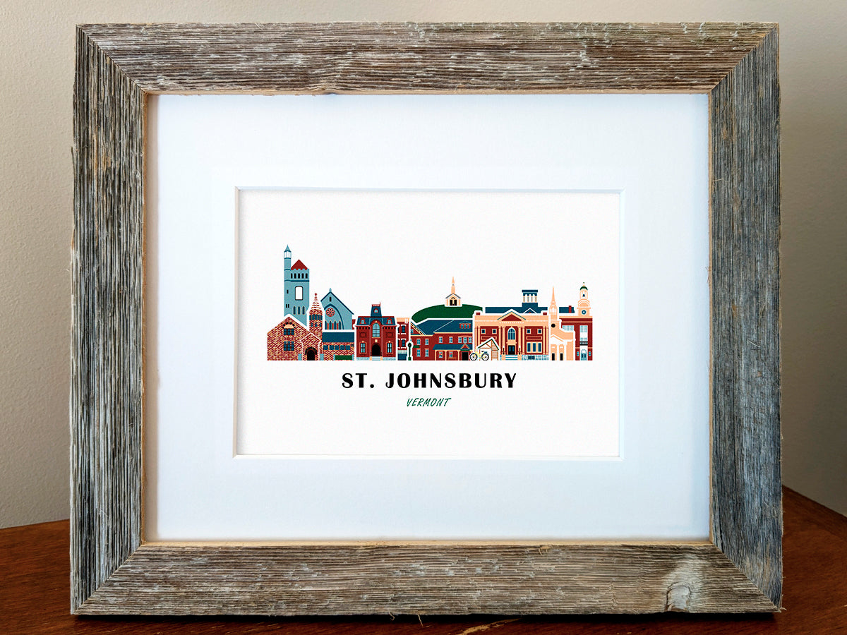 Framed art print of buildings arranged in a skyline with the text St. Johnsbury Vermont