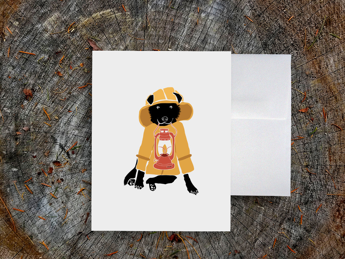 Greeting card with image of a dog with a yellow fisherman jacket holding a lantern.