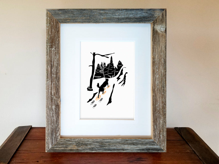 Framed art print of a black dog with snowshoes and forest background