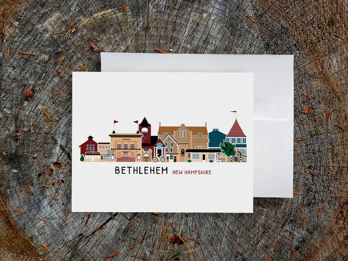 Card with illustration of buildings labeled 'Bethlehem, New Hampshire' on a wooden surface