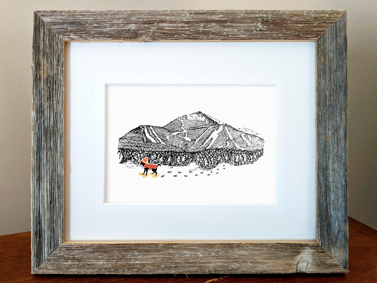 Framed art print of a dog with a red vest and hat snow shoeing with mountains in the background