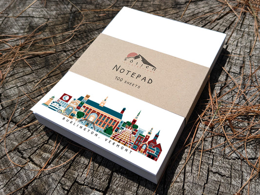 Notepad with illustration of Burlington, Vermont buildings in skyline on a wood surface