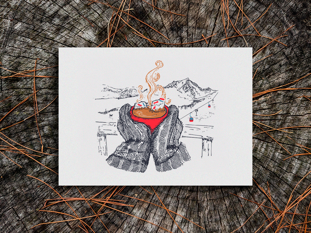 Art print illustration of thick winter mittens holding a red cup of hot chocolate, with mountains and chair lift in the background, displayed on a wooden surface.