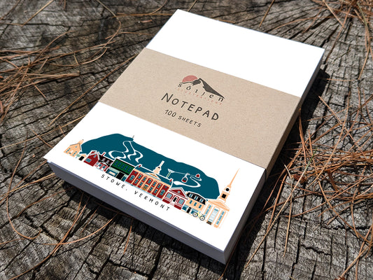 Notepad with illustration of Stowe, Vermont buildings in skyline on a wood surface