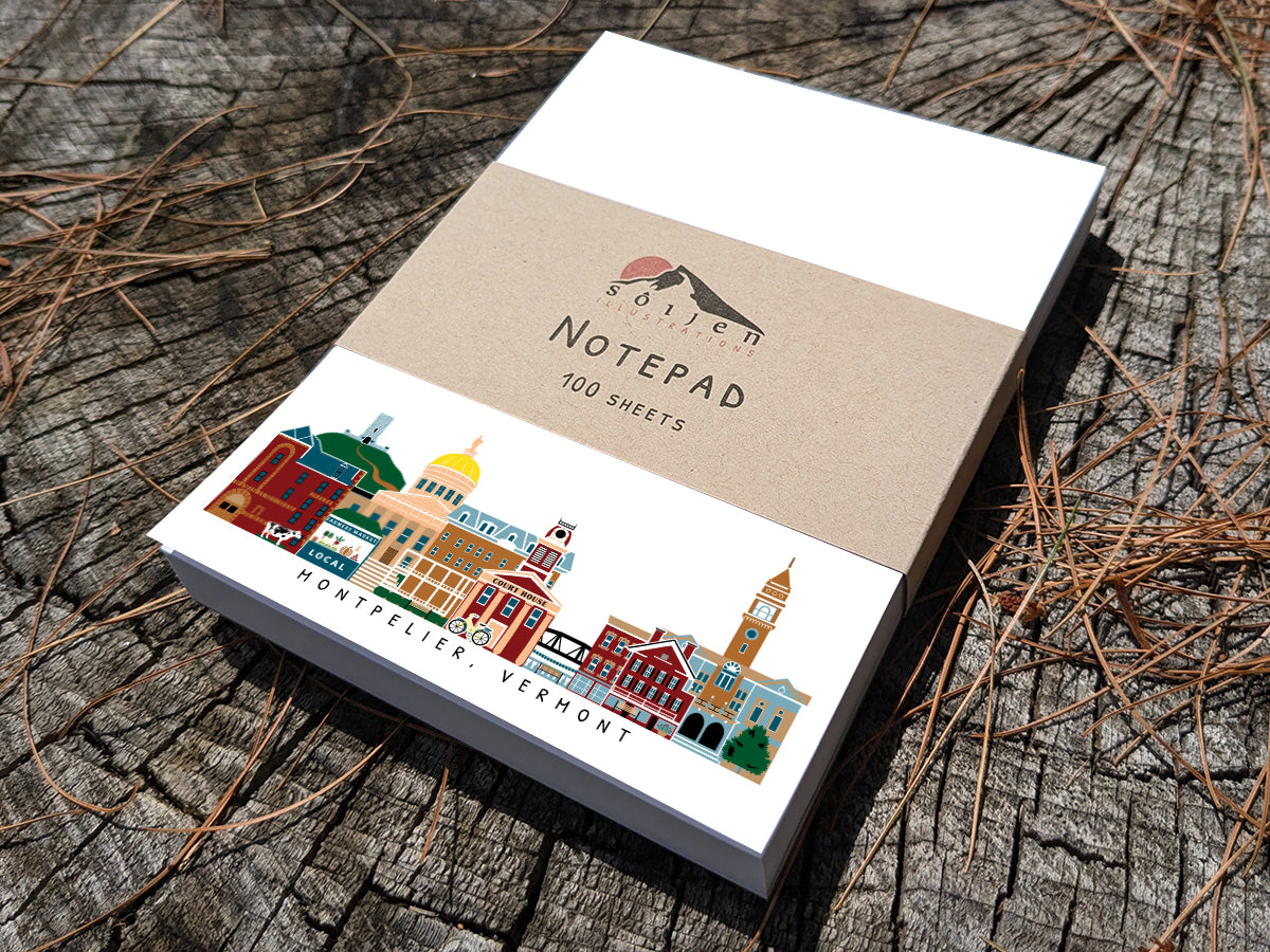 Notepad with illustration of Montpelier, Vermont buildings in skyline on a wood surface