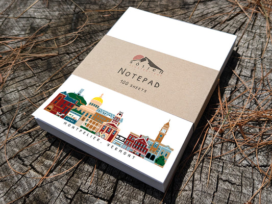 Notepad with illustration of Montpelier, Vermont buildings in skyline on a wood surface