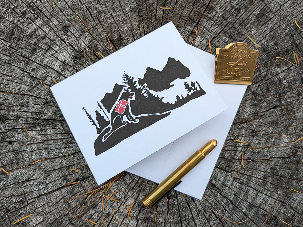 Greeting card with dog hiking in the mountains with envelope.