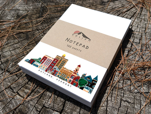 Notepad with illustration of Rutland, Vermont buildings in skyline on a wood surface