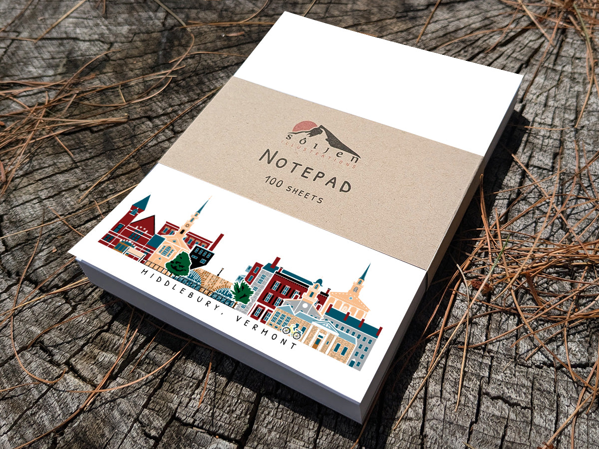 Notepad with illustration of Middlebury, Vermont buildings in skyline on a wood surface