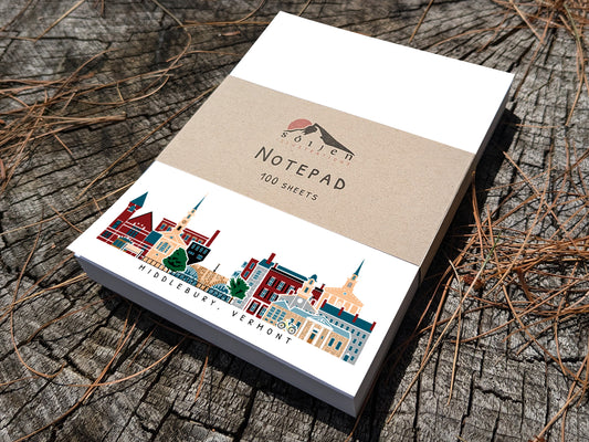 Notepad with illustration of Middlebury, Vermont buildings in skyline on a wood surface