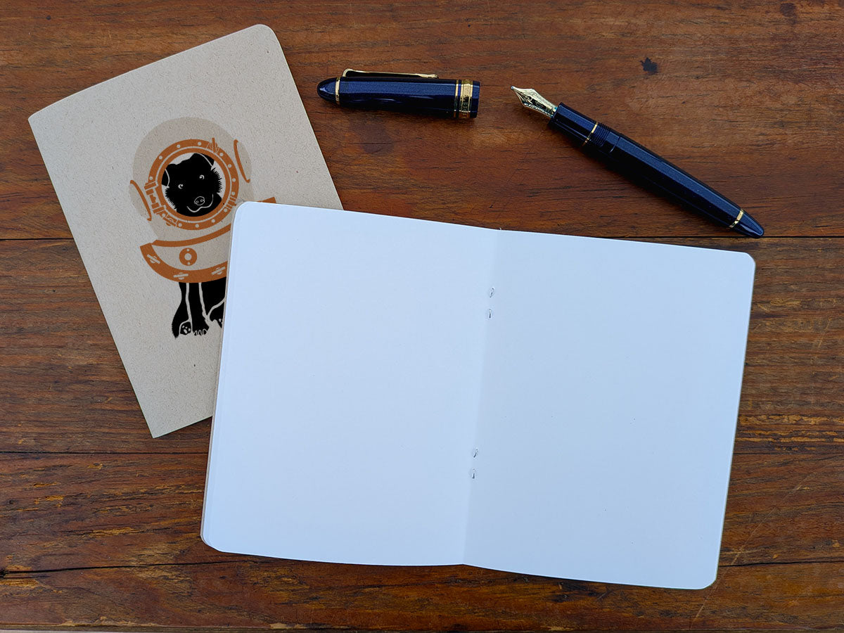 Open notebook with a pen on a wooden surface