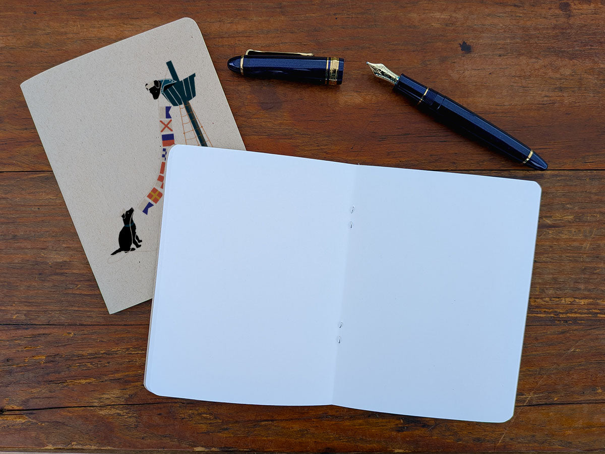 Open blank notebook with a pen and a pen on a wooden surface