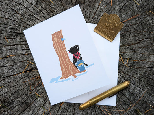 Greeting card with image of dog next to a maple syrup tap on a tree and bucket of maple syrup.