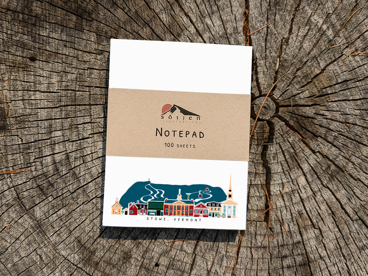 Notepad with illustration of Stowe, Vermont buildings in skyline on a wood surface