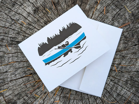 Greeting card with dog paddling in a canoe with envelope.