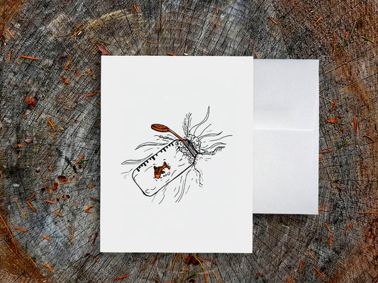 White card with a black ink drawing of a water bottle with red fish on a wooden surface.