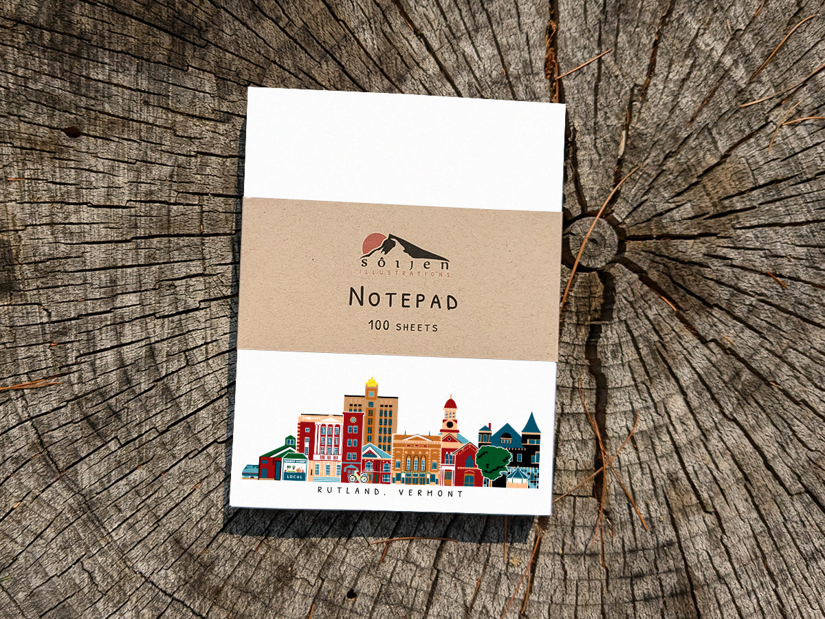Notepad with illustration of Rutland, Vermont buildings in skyline on a wood surface