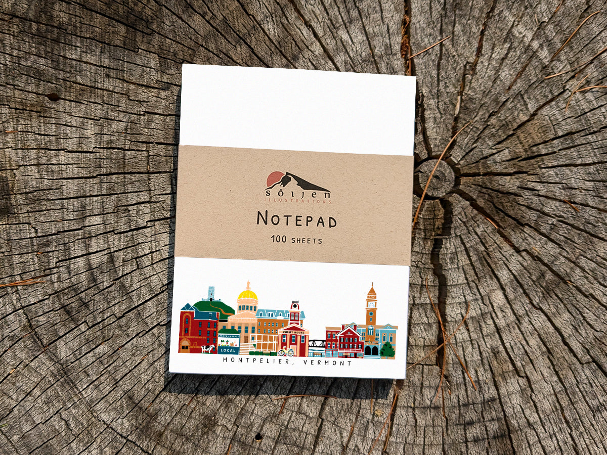 Notepad with illustration of Montpelier, Vermont buildings in skyline on a wood surface