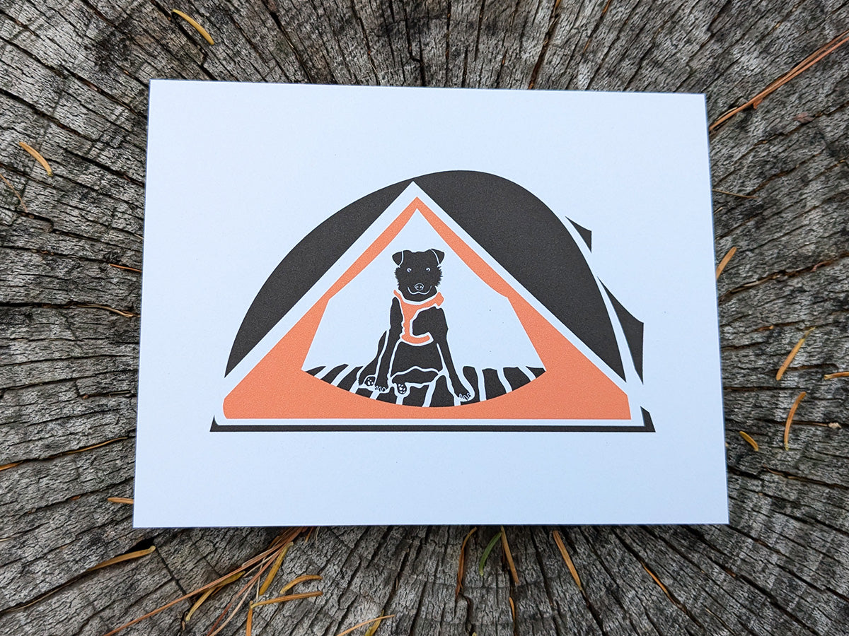 Greeting card with dog sitting in an orange tent.