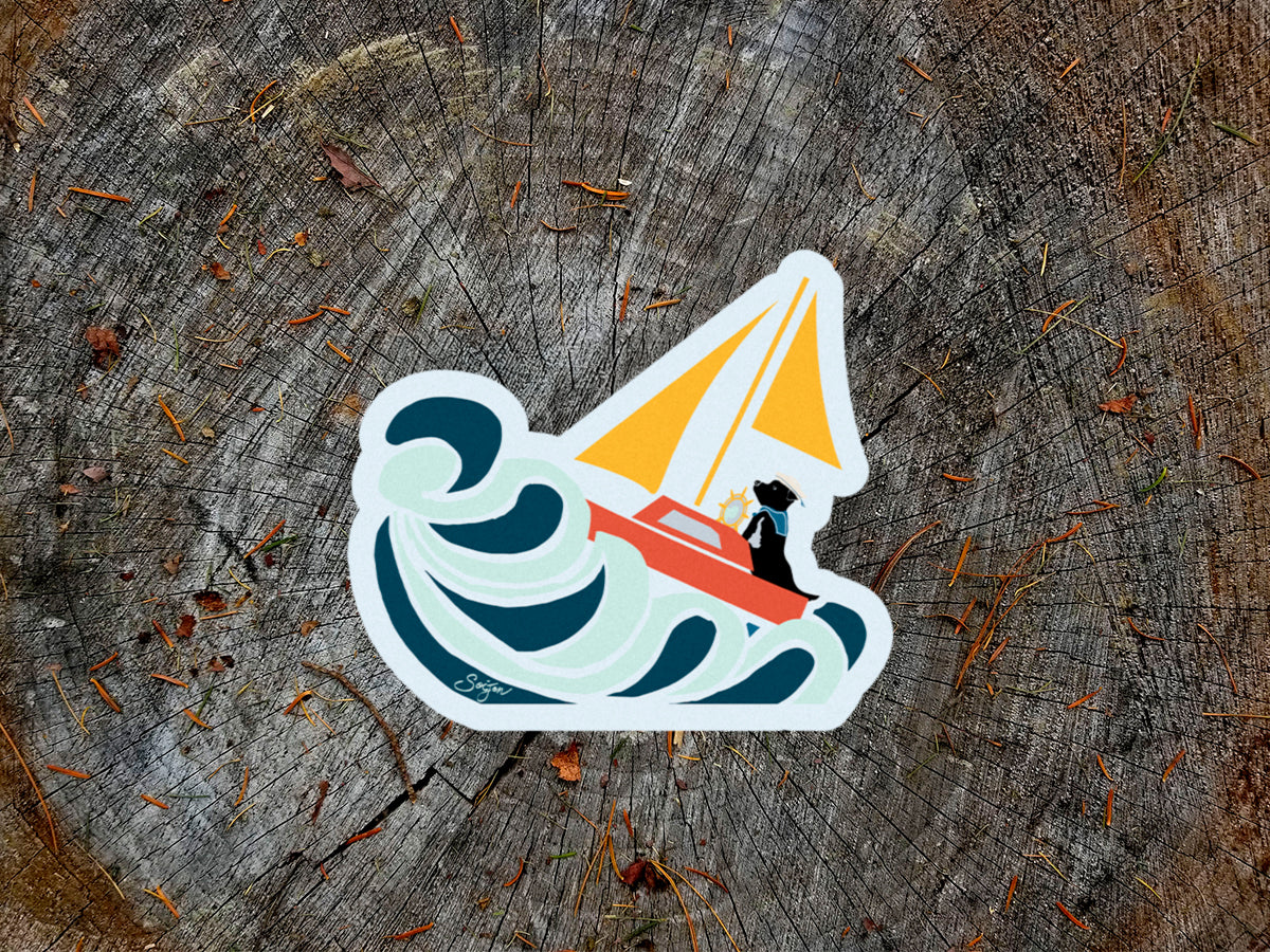 Sticker of a dog sailing through rough seas on a wooden surface.